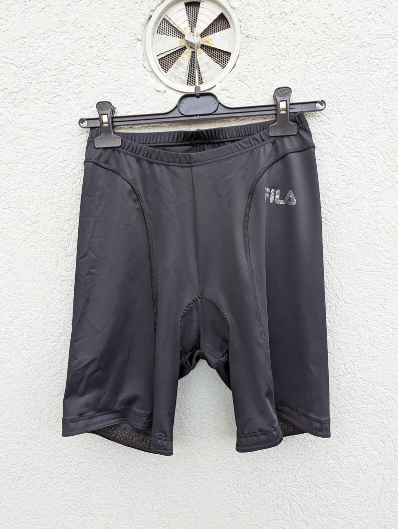 Puede incluir: Pantalones cortos de ciclismo negros hechos de tela lisa y el&aacute;stica con una zona de entrepierna acolchada para mayor comodidad. Los pantalones incluyen un logotipo de Fila impreso en tono plateado reflectante en el muslo izquierdo.