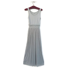 May include: A light gray sleeveless maxi dress with a gathered skirt and a fitted bodice. The dress is hanging on a wooden hanger.