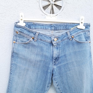 May include: A pair of light blue denim jeans with a classic five-pocket style. The jeans have a straight leg and a slightly faded wash.