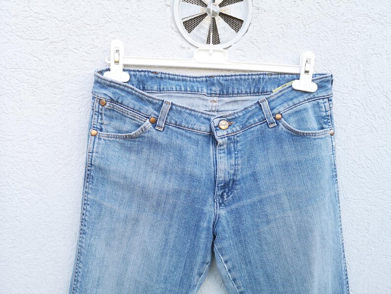 May include: A pair of light blue denim jeans with a classic five-pocket style. The jeans have a straight leg and a slightly faded wash.
