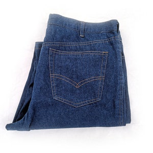 May include: A pair of folded blue denim jeans with a back pocket.