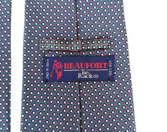 May include: A blue silk tie with a white and red geometric pattern. The tie has a label that reads "BEALFORT The Rack® 100% Silk Made in Italy".