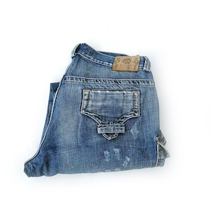 May include: A pair of blue denim jeans folded in half, with a brown leather patch that says "GALCI" on the back pocket.