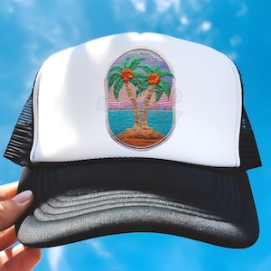 Può includere: Un cappello da camionista bianco e nero con una toppa ricamata colorata di due palme con fiori arancioni su uno sfondo di spiaggia.