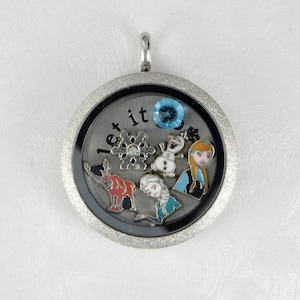 May include: Silver locket necklace with a glitter finish. The locket features a blue gem, a snowflake, a reindeer, Olaf, and Elsa from the movie Frozen. The locket has the words "Let it go" inscribed on it.