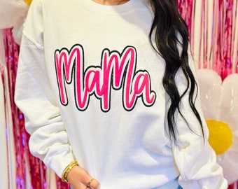 May include: White sweatshirt with a pink and black "Mama" graphic.