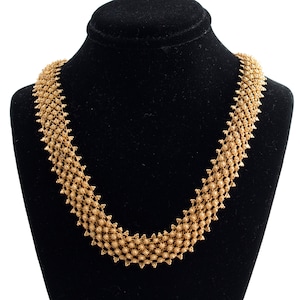 May include: A gold chain necklace with a delicate, intricate design. The chain is made of small, linked circles that create a delicate, feminine look.