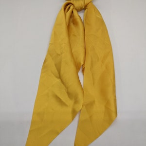 May include: A yellow satin hair scrunchie with a long, flowing tail.