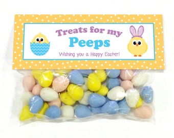 May include: A yellow and orange treat bag with white polka dots. The bag has a label that says "Treats for my Peeps" with a yellow chick in an egg and a yellow chick with bunny ears. The bag is filled with pastel-colored candy eggs.
