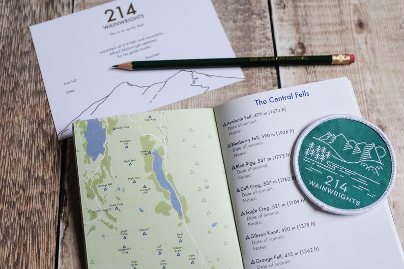 K&ouml;nnte beinhalten: Ein gr&uuml;ner und wei&szlig;er Aufn&auml;her mit dem Text "214 Wainwrights" und einer Illustration einer Bergkette. Der Aufn&auml;her befindet sich auf einer Seite mit einer Liste von Bergen und deren H&ouml;hen in Metern und Fu&szlig;. Die Seite ist auf den Abschnitt mit dem Titel "The Central Fells" ge&ouml;ffnet.