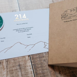 May include: A white card with a green patch that says "214 Wainwrights" and a line drawing of mountains. The card says "This is to certify that summited all 214 fells and mountains Alfred Wainwright selected for his guide books."  The card also has lines for "First fell: Date:" and "Final fell: Date:". A brown booklet with the text "Walking the Wainwrights" and a line drawing of mountains is next to the card.