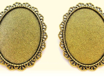 May include: Two gold-toned oval-shaped metal picture frames with a decorative scalloped edge.