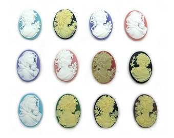 May include: Twelve oval-shaped cameo-style resin cabochons with a white cameo image of a woman's profile. The cabochons are in various colors, including black, white, pink, blue, green, and brown.