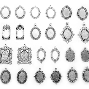 May include: A set of 20 silver-toned metal pendant trays with various ornate designs. The trays are oval, square, and rectangular in shape and have a smooth, polished finish.
