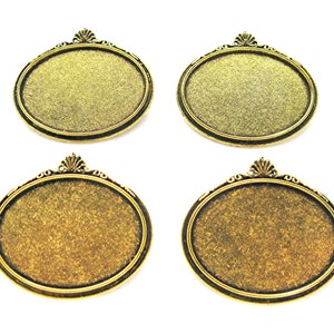 May include: Four gold-toned oval-shaped metal frames with ornate edges. The frames are blank and ready for a craft project.