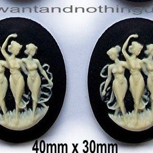 May include: Two black and white cameo buttons with a design of three women dancing. The buttons are oval shaped and measure 40mm x 30mm.