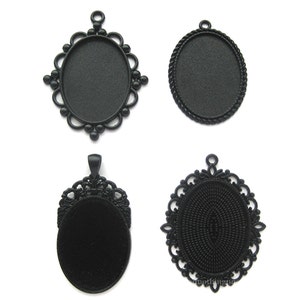 May include: Four black metal oval pendant trays with different designs. The trays are blank and ready to be filled with resin, paint, or other embellishments.