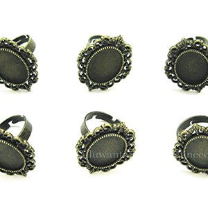 May include: Six antique gold-toned rings with oval-shaped bezels. The bezels have a decorative filigree design.