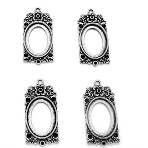 May include: Four silver-toned metal pendant frames with an oval opening. Each frame features a floral design with a raised flower in the center.