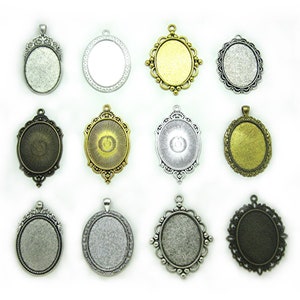 May include: Twelve oval-shaped metal pendant trays with different decorative edges. The trays are silver, gold, and bronze in color. They are all blank and ready to be filled with resin, photos, or other embellishments.