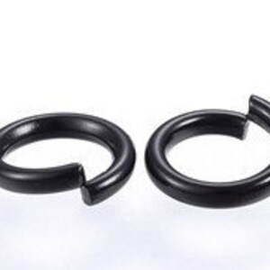May include: Two black hoop earrings. The earrings are simple and sleek, with a smooth finish.
