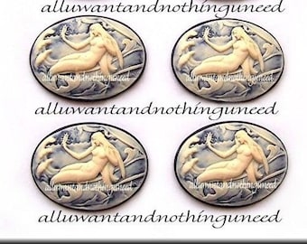 May include: Four oval-shaped ceramic cabochons with a white and blue design. Each cabochon features a mermaid with a tail, holding a mirror in one hand and a shell in the other. The mermaids are surrounded by waves and sea creatures.