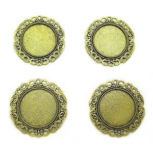 May include: Four gold-toned metal round frames with ornate edges. The frames are blank and ready for a cameo or other embellishment.