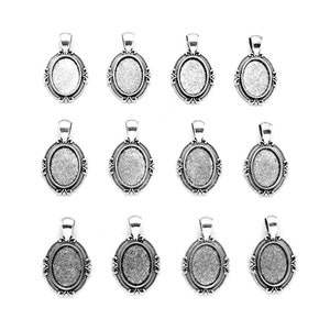 May include: Twelve silver-toned oval pendant trays with ornate frames. Each pendant has a loop at the top for a chain and a recessed area for inserting a photo or other small item. The pendants are arranged on a white background.