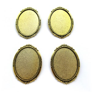 May include: Four gold-toned oval-shaped metal frames with ornate edges. The frames are blank and ready for adding a design or image.