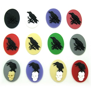 May include: Twelve round, flat, decorative buttons with a black raven design. Six buttons feature a raven perched on a branch, while the other six feature a raven perched on a skull. The buttons are available in a variety of colors, including black, white, red, green, yellow, purple, and gray.