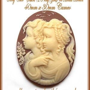 May include: Ivory cameo featuring two sisters with detailed facial features and hair, set against a mocha brown background. The cameo is 40mm x 30mm.