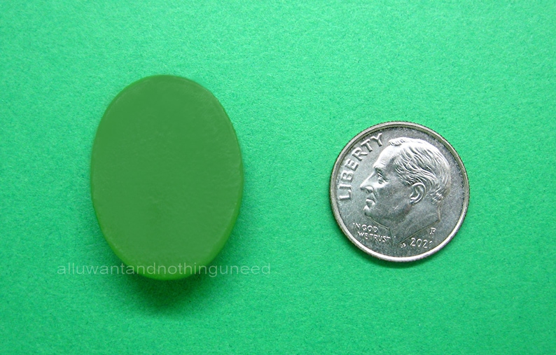 May include: A green oval-shaped glass piece, approximately the size of a dime.