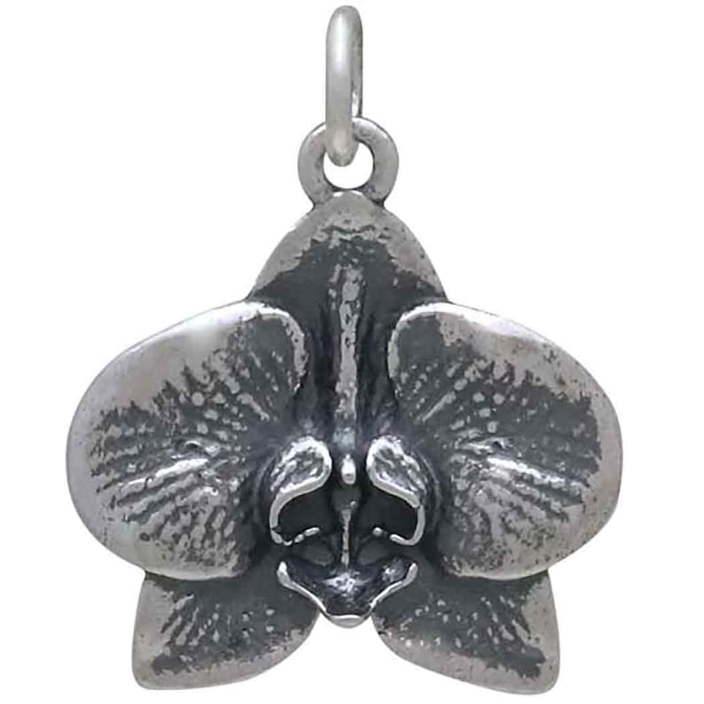 Peut inclure: Un charme en argent en forme de fleur d'orchid&eacute;e. Le charme est d&eacute;taill&eacute; et r&eacute;aliste, avec une surface textur&eacute;e.