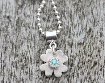 Four leaf clover luck pendant handmade in brushed organic silver with blue gemstone