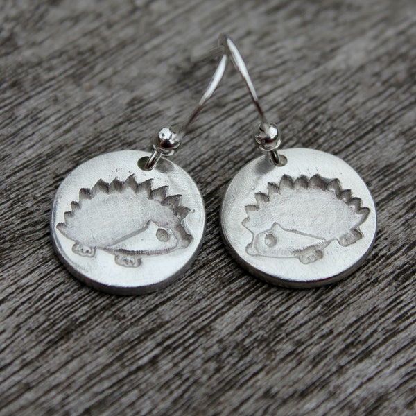 Hedgehog dangle earrings handmade in silver with an embossed hedgehog. Inspired by nature and wildlife. Perfect for a hedgehog lover.