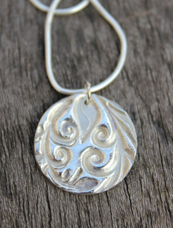 Large silver ocean wave pendant on a necklace chain, maori inspired