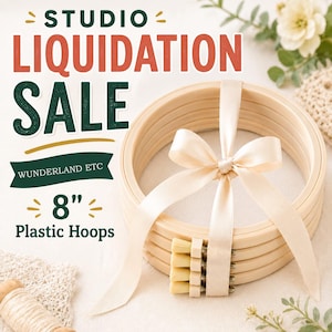 May include: A stack of four round, light-colored plastic embroidery hoops tied together with a cream-colored satin ribbon. The text in the image reads STUDIO LIQUIDATION SALE, WUNDERLAND ETC, and 8" Plastic Hoops in green and red lettering.