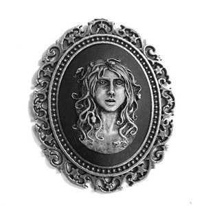 May include: Three silver-toned cameo brooches with ornate frames. Each brooch features a black and white portrait of a woman with a different expression.