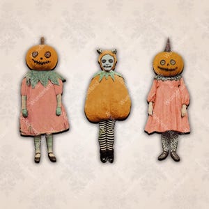 May include: Three vintage-style Halloween figures. Two figures wear pumpkin heads with stitched smiles and eyes, and pink dresses. The third figure is in a pumpkin costume with a cat-like face. All have painted features and are set against a patterned background.