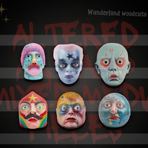 May include: Six colorful, hand-painted masks with whimsical features. The masks are made of wood and have a variety of textures and details. The masks are arranged in two rows of three. The masks are all different colors and have different facial expressions. The masks are all unique and have a whimsical and playful feel. The text "Altered and Mixed Media" is written in red across the top of the image. The text "Wonderland Woodcuts" is written in white in the top right corner of the image.
