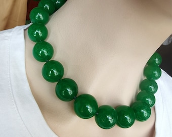 May include: A green jade necklace with large round beads. The necklace is made of natural jade and is a beautiful and elegant piece of jewelry.