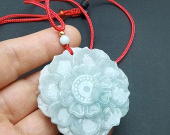 May include: A light green jade pendant carved in the shape of a flower, suspended from a red cord necklace. The pendant has detailed petal carvings and a central design. The necklace features a sliding knot for adjustable length.