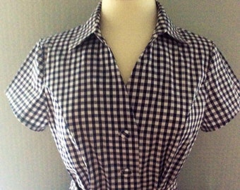 May include: A black and white gingham dress with a collared neckline, short sleeves, and a tie belt.