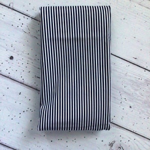 May include: A black and white striped fabric with thin white stripes and wider black stripes.