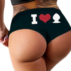 May include: Black underwear with a white "I love" graphic and a red heart. The graphic also includes a white outline of a heart shape.