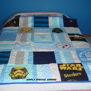 May include: A blue and white patchwork quilt made from t-shirts. The quilt features various logos and images, including Star Wars, Pittsburgh Steelers, Pittsburgh Penguins, and Darth Vader. The quilt is edged with a blue trim and has the text "SIMPLY SPECIAL SEWING" in the bottom right corner.