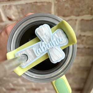 May include: A white ceramic mug with a black handle and the text "But First, Coffee" in a bold, black font. The mug is set against a neutral background, highlighting its simple design.