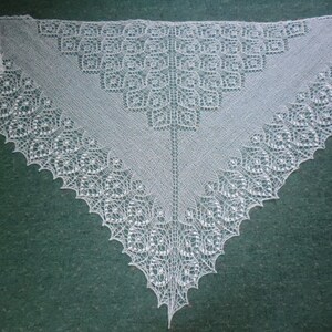 May include: A white crocheted shawl with a delicate lace pattern. The shawl is triangular in shape and has a scalloped edge.