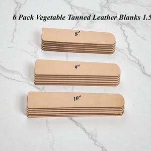 May include: Six packs of vegetable tanned leather blanks in varying sizes: 8", 9", and 10" long. The blanks are a light tan color and stacked in neat rows. The text "6 Pack Vegetable Tanned Leather Blanks 1.5" is at the top.