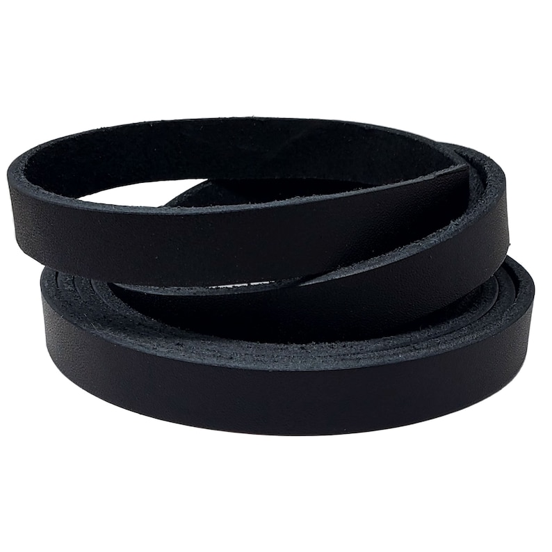 May include: A coiled black leather strip, likely for crafting or accessories. The leather appears smooth and has a consistent dark color. The strip is rolled in a spiral, showcasing its flexibility and texture. The image is well-lit, highlighting the material's quality.